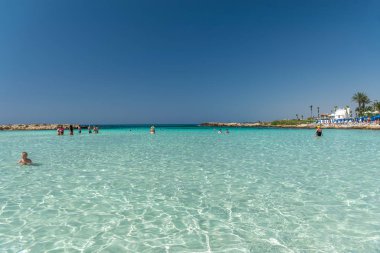 CYPRUS, NISSI BEACH - MAY 12/2018: Tourists relax and swim on one of the most popular beaches on the island.