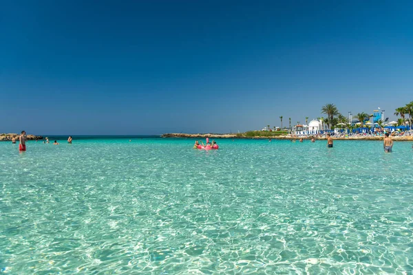 CYPRUS, NISSI BEACH - MAY 12/2018: Tourists relax and swim on one of the most popular beaches on the island.