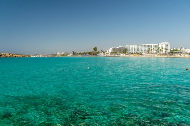 CYPRUS, NISSI BEACH - MAY 12/2018: Tourists relax and swim on one of the most popular beaches on the island.
