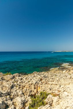 CYPRUS, NISSI BEACH - MAY 12/2018: Tourists swim on catamarans and kayaks in the popular bay of the Mediterranean Sea.