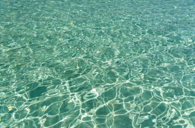 Sıcak güneşin altında deniz suyunun yüzeyi.