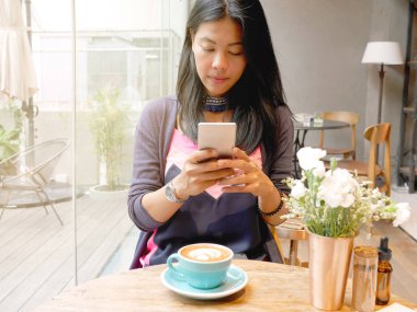 kahve dükkanında cep telefonu kullanan kadın