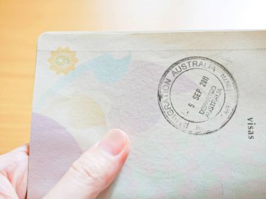 Avustralya Göçmenlik damga Passport'a tutan el 