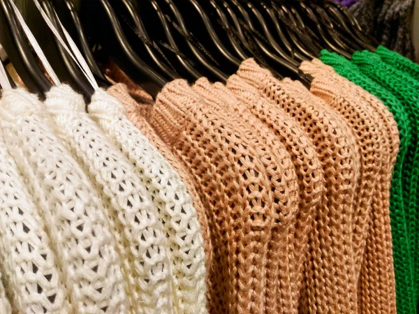 Roupas de malha penduradas em boutique shop — Fotografia de Stock