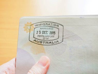 Avustralya Göçmenlik damga Passport'a tutan el 