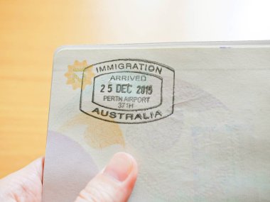 Avustralya Göçmenlik damga Passport'a tutan el 