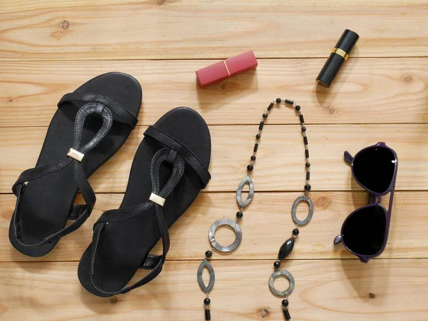 Collection of women\'s accessories. Sandals, sunglasses, necklace and lipstick. Fashion concept