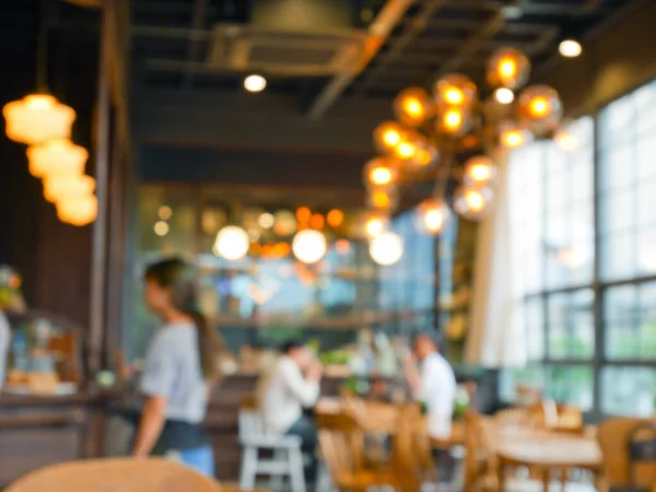 Kafe arka planında bulanık insanlar ve bokeh ışığı