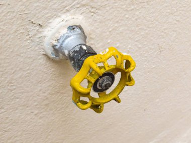 Sarı musluğun üst görüntüsü yumuşak arka planda izole edilmiş. Hidrolik vana.