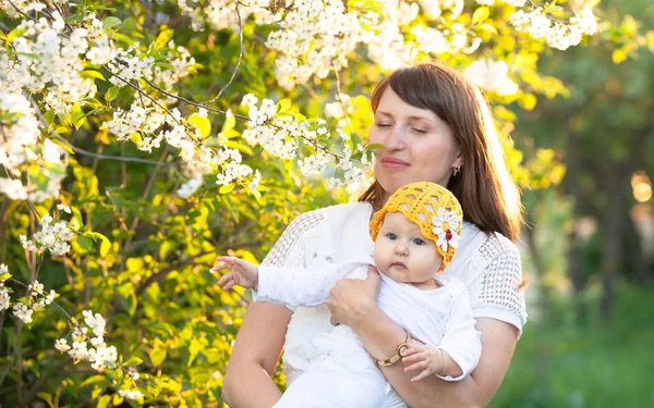 Au jardin de printemps avec maman cerise en fleurs et bébé fille profiter de la nature — Photo