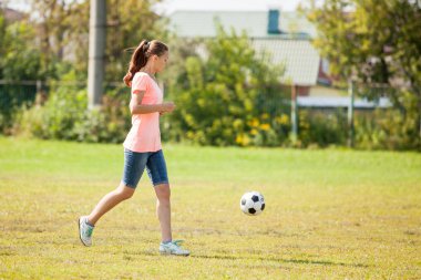 Sporcu kız futbol oynadı topu başladı .