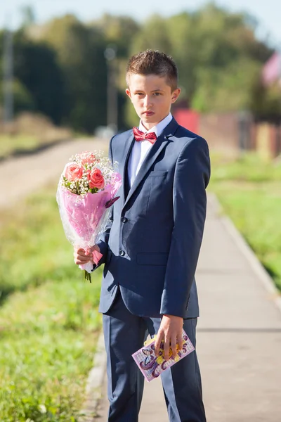 Jovem de terno com buquê de rosas — Fotografia de Stock