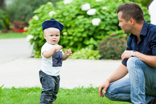 Petit garçon mignon faisant les premiers pas avec mon père lors d'une promenade dans le parc — Photo