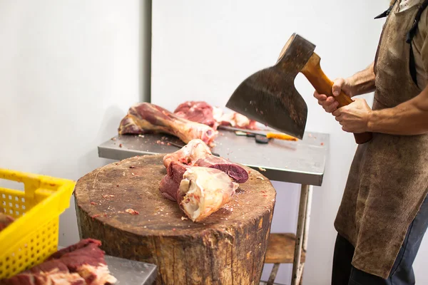 Macellaio che taglia la carne con un'ascia — Foto Stock