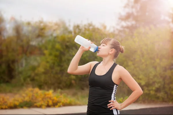 Woman drinking water during sports — ストック写真