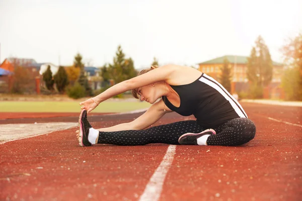 Mujer haciendo ejercicios de calentamiento antes de correr — Foto de Stock