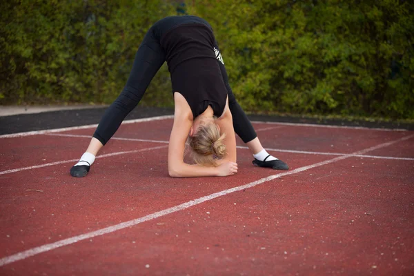 Sports teenage girl in the stadium performs gymnastic exercises — Stock Photo, Image