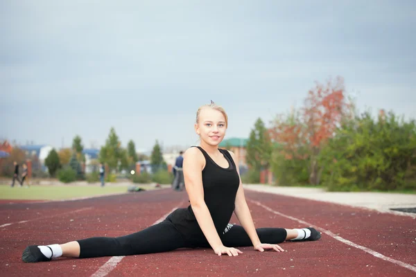 Девушка-подросток на стадионе выполняет гимнастические упражнения — стоковое фото