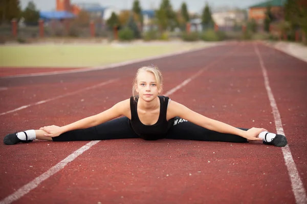 Sportliches Teenie-Mädchen im Stadion macht Turnübungen — Stockfoto