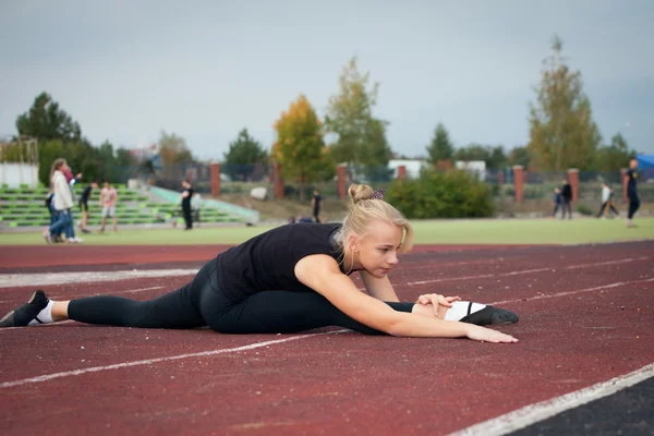 Sport teenage pige i stadion udfører gymnastik øvelser - Stock-foto