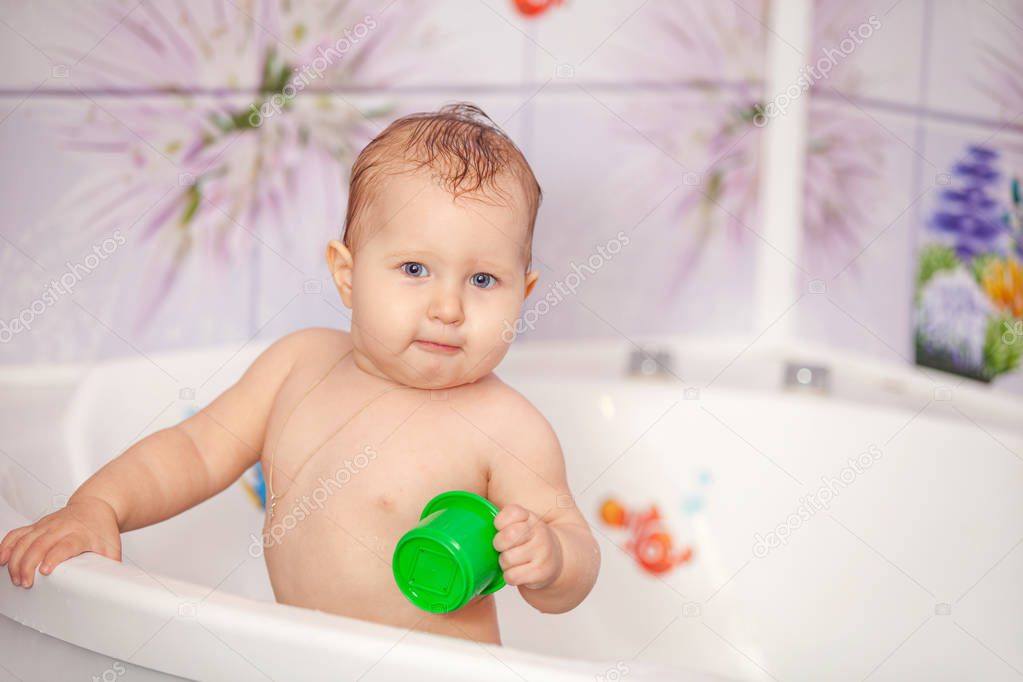 Happy baby swims in the bathtub