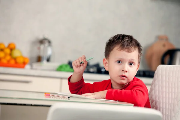 Inspirado por el niño dibuja un cuadro en el papel en la mesa —  Fotos de Stock