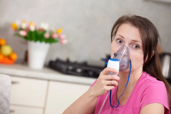 Mladá žena, která dělá inhalace s rozprašovač doma — Stock fotografie