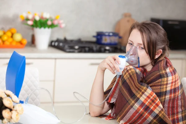Jonge vrouw inhaleren met een vernevelaar thuis doen — Stockfoto