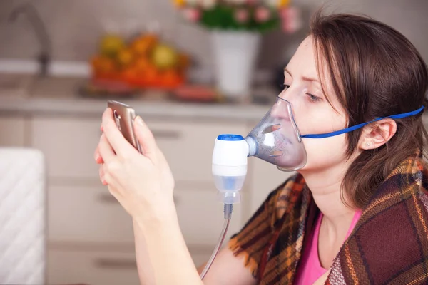 Mladá žena, která dělá inhalace s rozprašovač doma — Stock fotografie