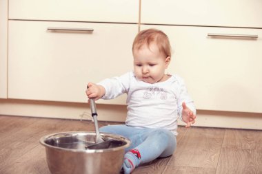 Küçük bir çocuk mutfakta yerde çalış