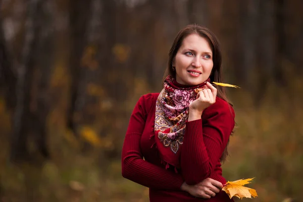 Bella giovane donna con foglie di acero giallo in mano — Foto Stock