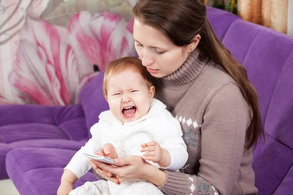 電話の女性は、泣いている子を無視します。赤ちゃんが泣いています。 — ストック写真