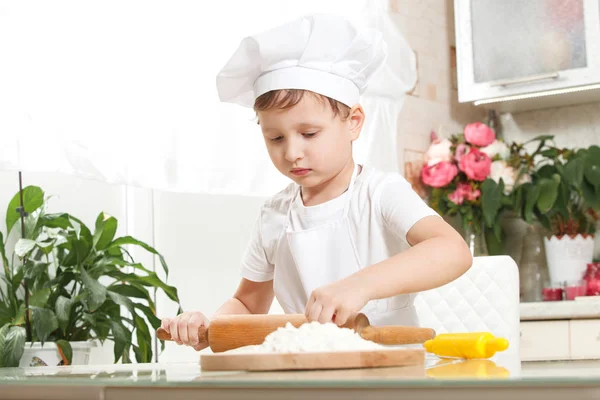 Dziecko wyrabia ciasto w mące — Zdjęcie stockowe