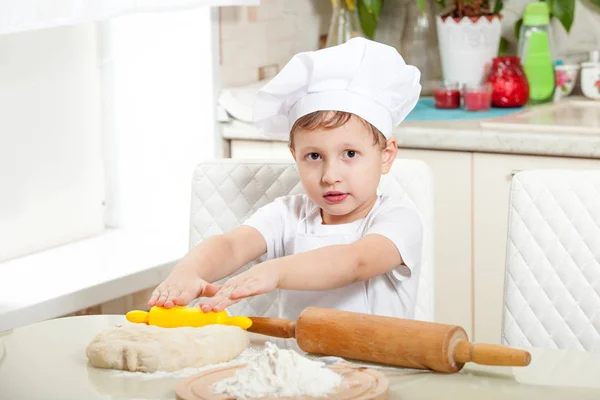 Ребенок месить тесто в муке — стоковое фото