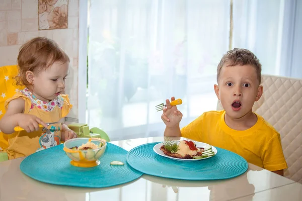 テーブルで健康的な夕食を食べて幸せな小さな子供たち — ストック写真