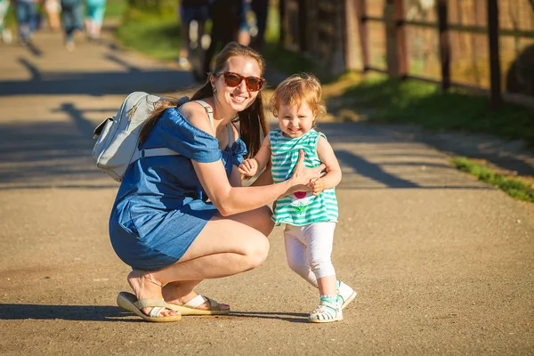 Una joven con una niña caminando por el zoológico. Madre e hija . —  Fotos de Stock