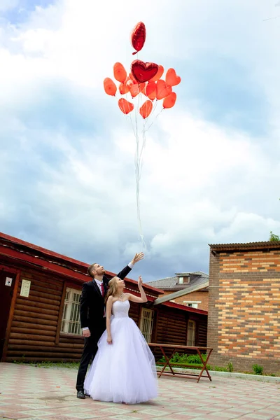 On the day of the wedding, the couple releases a bunch of red balloons in the form of hearts into the sky in happiness