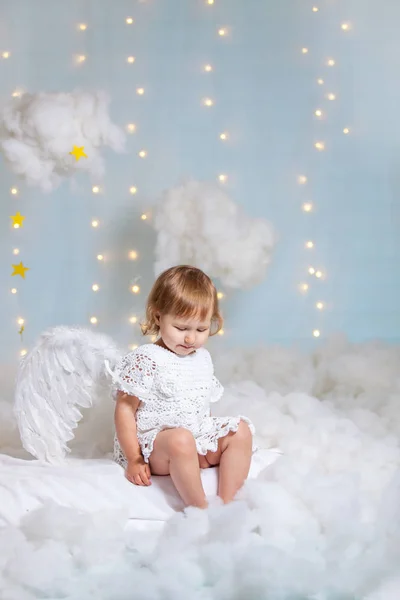 Bebê anjo sentado nas nuvens olhando para baixo — Fotografia de Stock