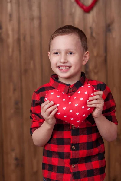 Día de San Valentín de un lindo bebé con un corazón rojo en sus manos . —  Fotos de Stock