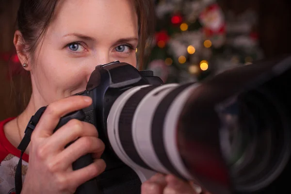 Kvinnan fotograf med digital kamera, tar en bild medan du tittar på kameran. — Stockfoto