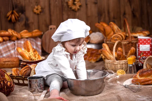 Aşçı, un, tüm dikkatli bir şekilde kneads gibi küçük bir kız giyinmiş — Stok fotoğraf