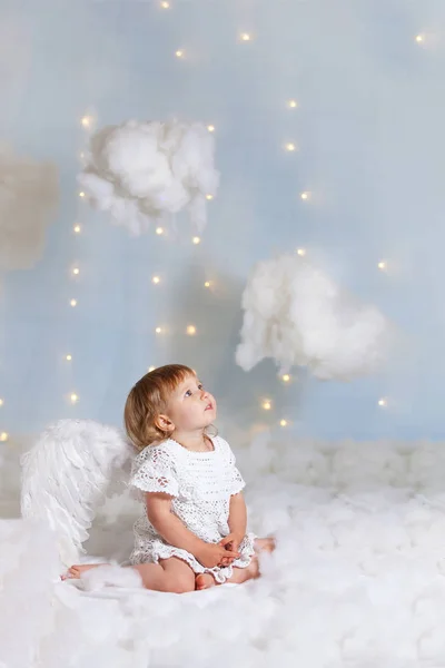 Bebê anjo sentado nas nuvens olhando para cima — Fotografia de Stock