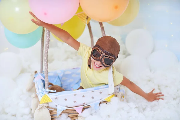 男婴坐在云中的气球篮子里 戴着飞行员的帽子和眼镜旅行和飞行 自由创造或想象的概念 空中风景梦幻般的仙女就像在梦里 — 图库照片