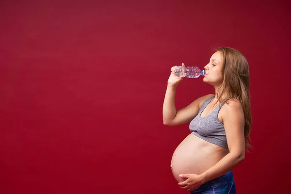 Беременная Женщина Спортивной Одежде Питьевая Вода После Занятий Спортом Красном — стоковое фото