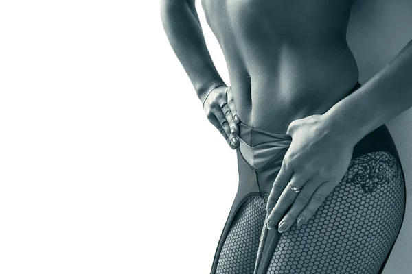 Close-up of a hard stomach of a Athletic young woman on a white background. black and white image. Sexual beautiful attractive flat stomach of woman, wearing tight pants leggings tracksuit copy space.