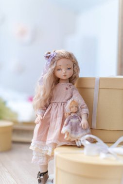 Yaşayan insanlara çok benzeyen tekstil ürünlerinden elle yapılmış iki oyuncak bebek. Hediyelerle dolu kutuların üzerinde dur. Tatil için oyuncak bebek yapıyorlar. Bebek annesi ve küçük bir çocuğu. Oyun 