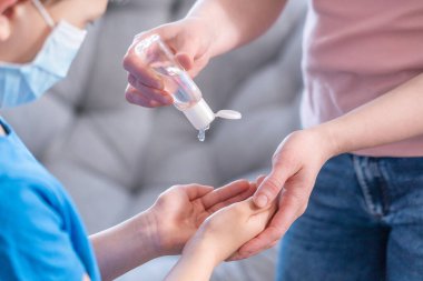 Alışveriş yaparken, seyahat ederken maskeli çocuklar. Anne ve çocuk koronavirüs ve grip salgını sırasında yüz maskesi takıyor. Virüs ve hastalık koruması, kalabalık bir yerde el dezenfektanı. anonimlik
