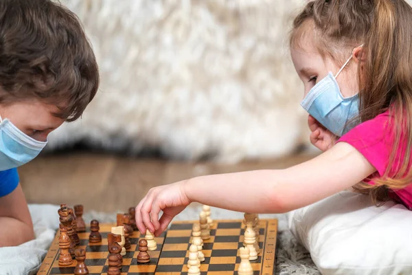 Gyerekek Orvosi Maszkban Sakkoznak Arcukon Földön Fekszenek Szabadidő Szórakozás Gyermekek — Stock Fotó