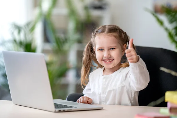 小さな女の子はノートパソコンを使って家から学びます 子供は喜んで笑顔で遠隔で知識を得る デジタルコンセプトEラーニングは 流行の間に 隔離と自己分離 遠隔Eラーニング — ストック写真
