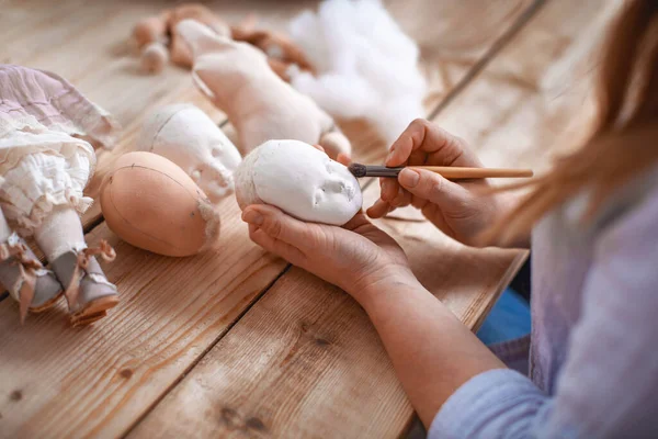 Workflow, masters of making handmade dolls, made by hand from textiles, in retro style. designer doll with a human face. Shaping the doll\'s face. Companion doll. creating dolls, an exclusive gift